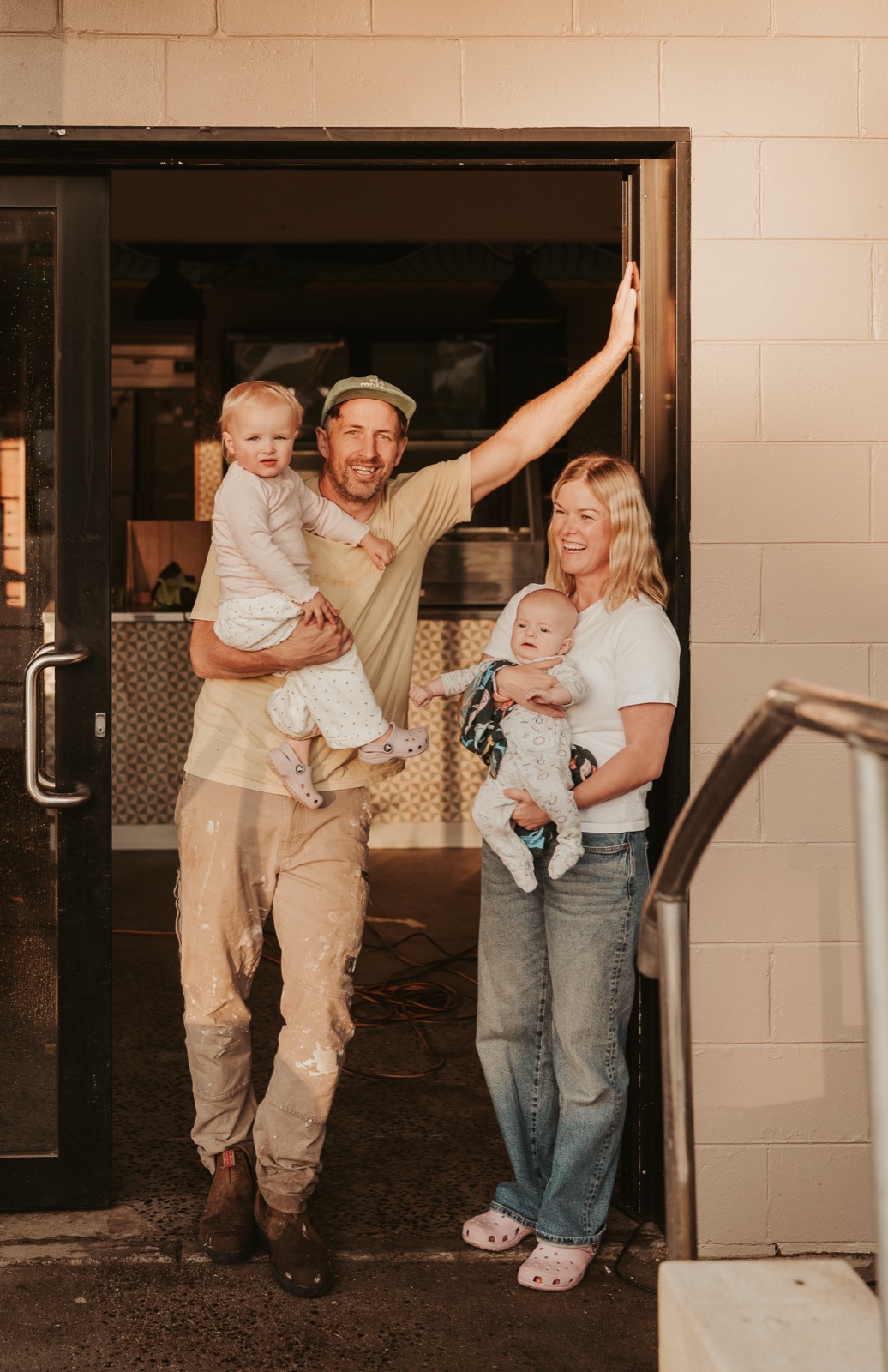 Kade and family in the doorway of the Smiths Beach General Store kiosk, golden-hour light